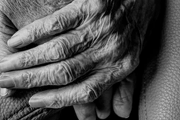 Close up of one elderly person's hands holding another hand