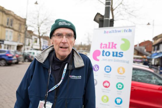 Man standing in front of a healthwatch banner