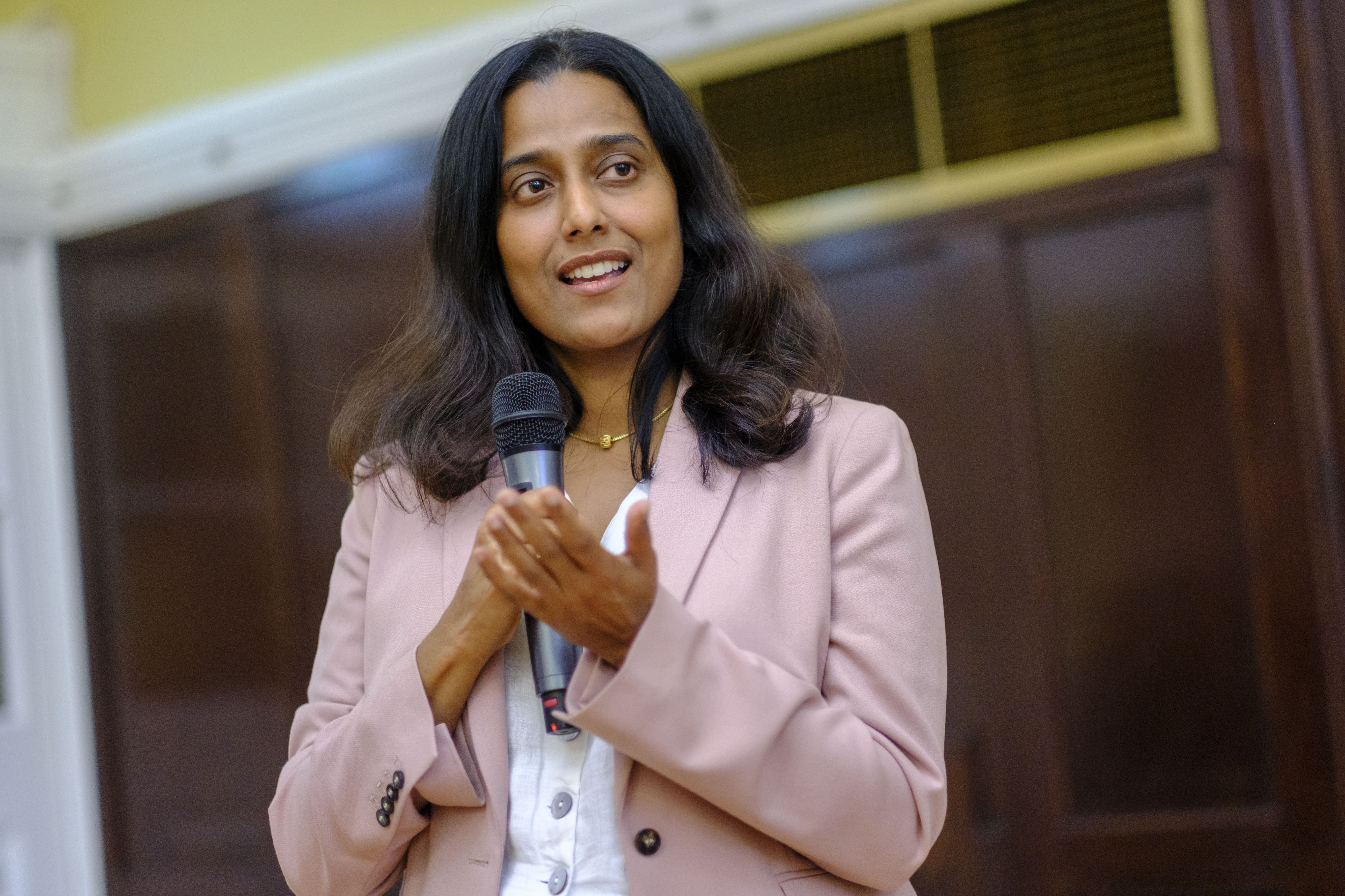 A photo of a woman holding a microphone as she speaks