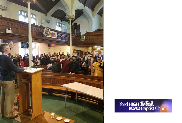 A church pastor in a pulpit, facing the standing church congregation