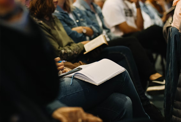 A group of people sat down at a meeting