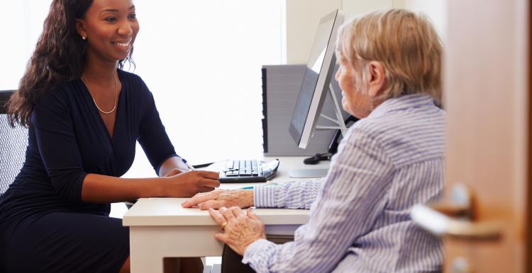 A photo of a patient with a doctor who is writing notes