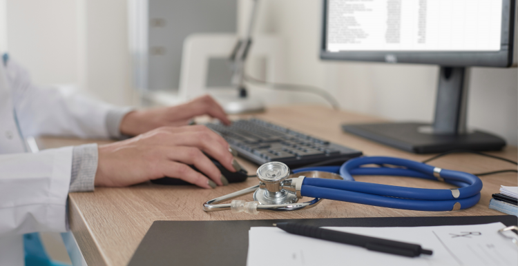 A photo of a doctor at a computer