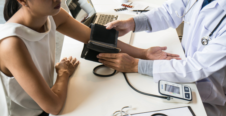 A photo of a woman with a doctor who is taking her blood pressure
