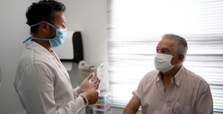 A consultant speaking to a seated patient