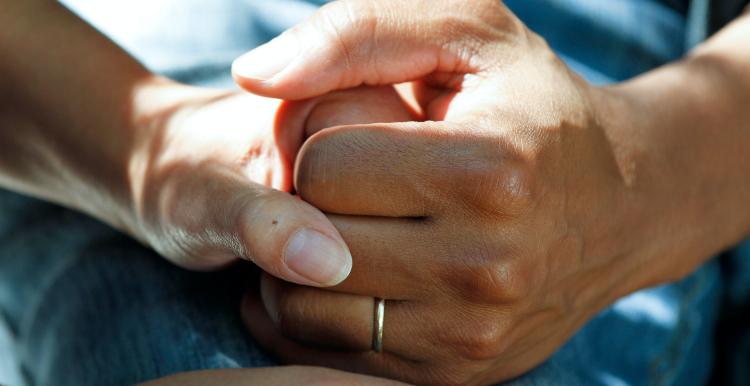 Close-up of a medical care worker holding someone's hand