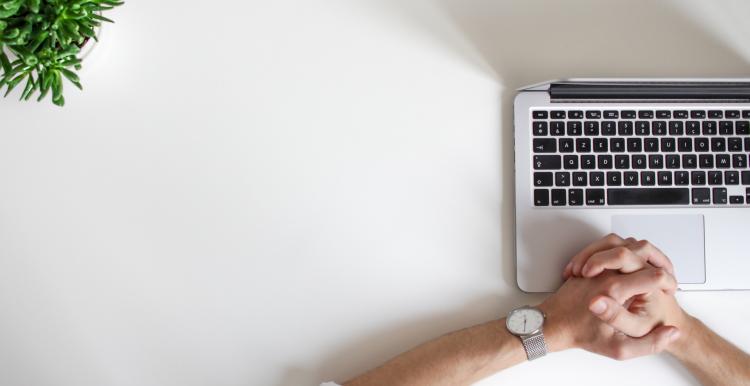 A person looking at their laptop, waiting