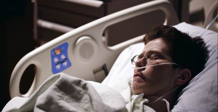 woman in hospital bed with tubes in her nose