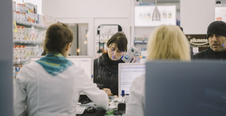 People queuing at at check out counter at a pharmacy