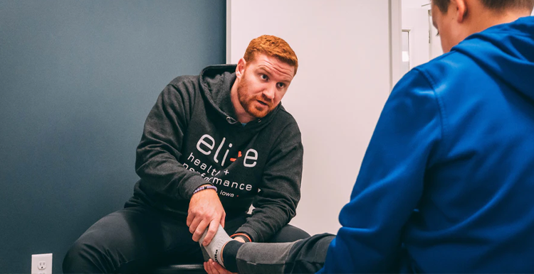 physio therapist helping a man to exercise his leg