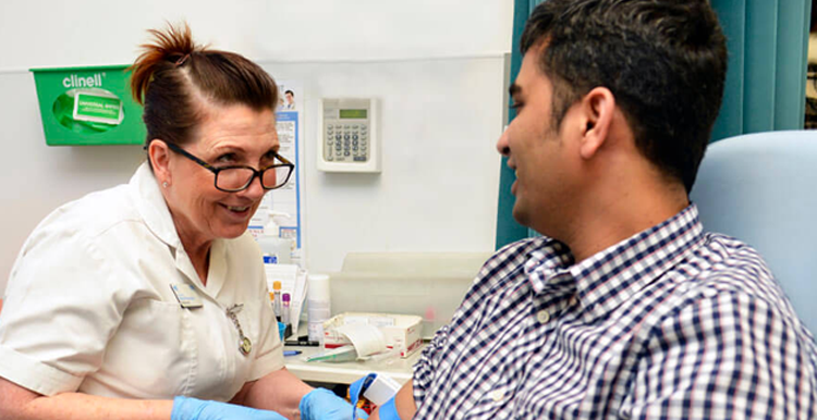 Phlebotomist taking blood from a male patient