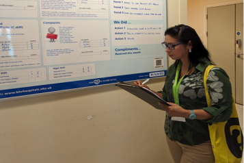 volunteer looking at hospital noticeboard