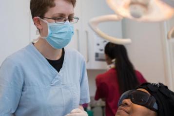 Dental surgeon with patient sitting in the chair