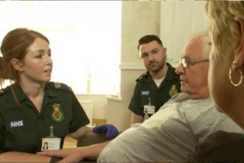 female paramedic talking to and elderly man