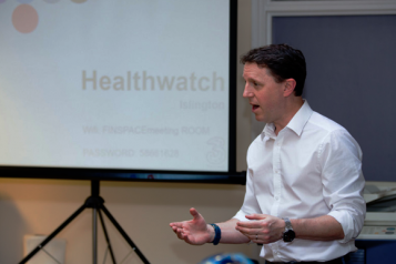 A Healthwatch staff member giving a Powerpoint presentation