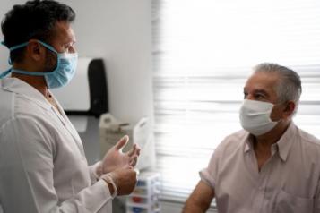 A consultant speaking to a seated patient