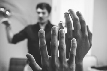 A community meeting with two people holding up their hands to ask a question