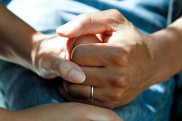 Close-up of a medical care worker holding someone's hand