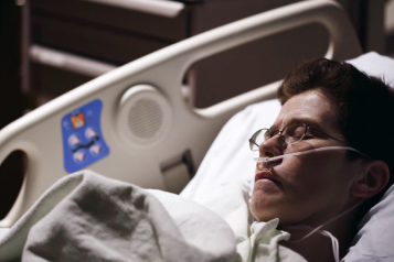 woman in hospital bed with tubes in her nose