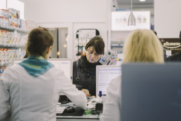 People queuing at at check out counter at a pharmacy