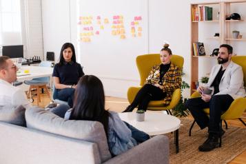 A group of professionals sat in a circle at a meeting