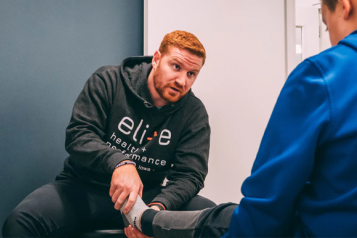 physio therapist helping a man to exercise his leg