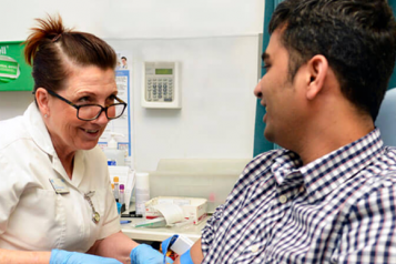 Phlebotomist taking blood from a male patient