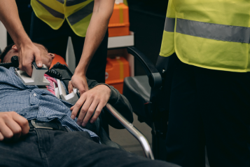 Paramedics in the back of an ambulance using a defibrillator on a man on a stretcher