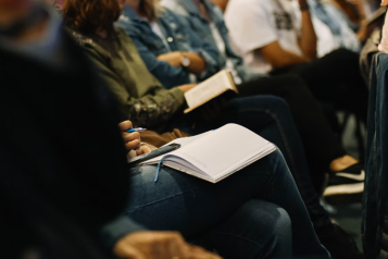 A group of people sat down, facing forward in a meeting