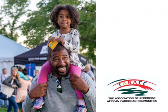 A black father and daughter at a fair. The daughter sitting on the father's shoulders