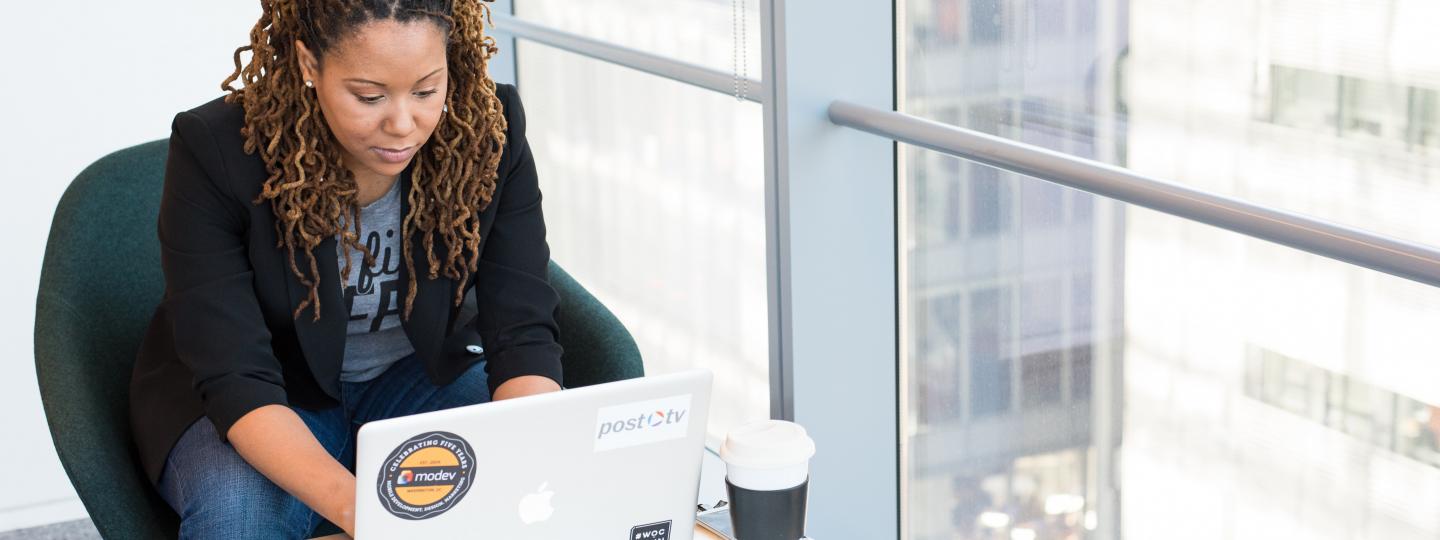 Woman sat at a desk using her laptop