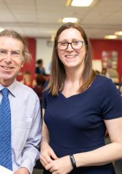 A man and a woman standing looking at the camera