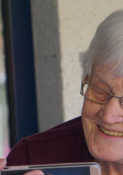 A carer holding a smart phone for her client