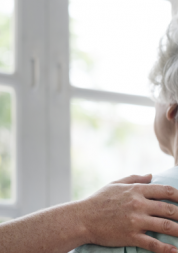 An elderly female patient talking to a nurse, overlooking a hospital window